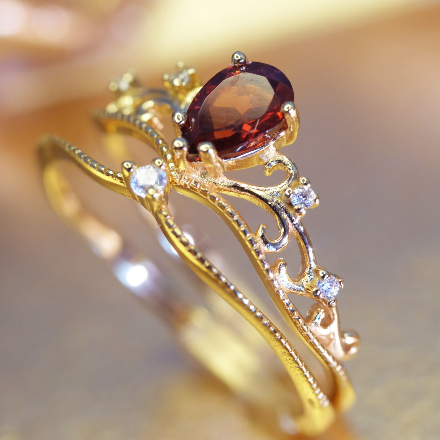 Drop-shaped garnet gold ring in crown design