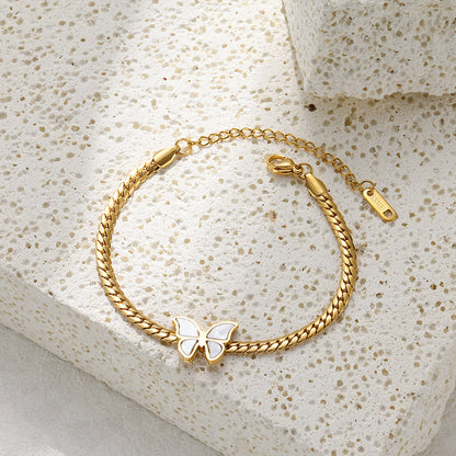 18k gold plated butterfly bracelet on a textured stone surface