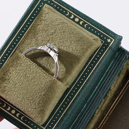 Silver ring in a green celestial book-style jewelry box