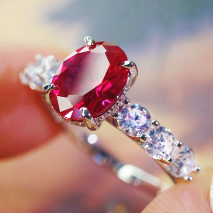 Oval red zircon ring with simulated diamond accents