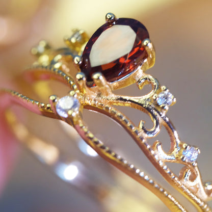 Drop-shaped garnet gold ring in crown design