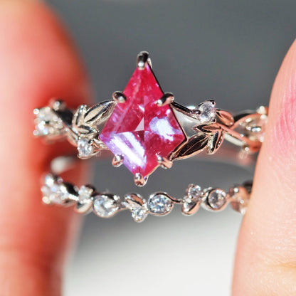 Purple alexandrite ring sets in leaf design held between fingers 