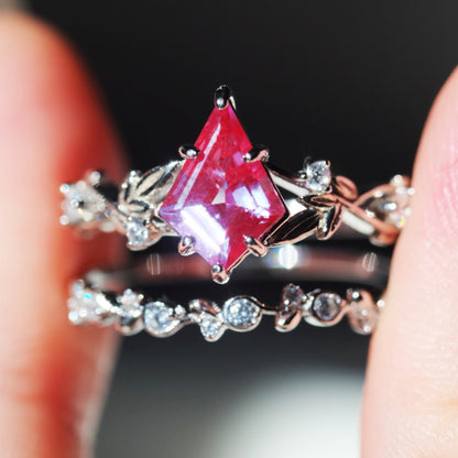 Rhombus purple alexandrite ring sets in leaf design held between fingers 