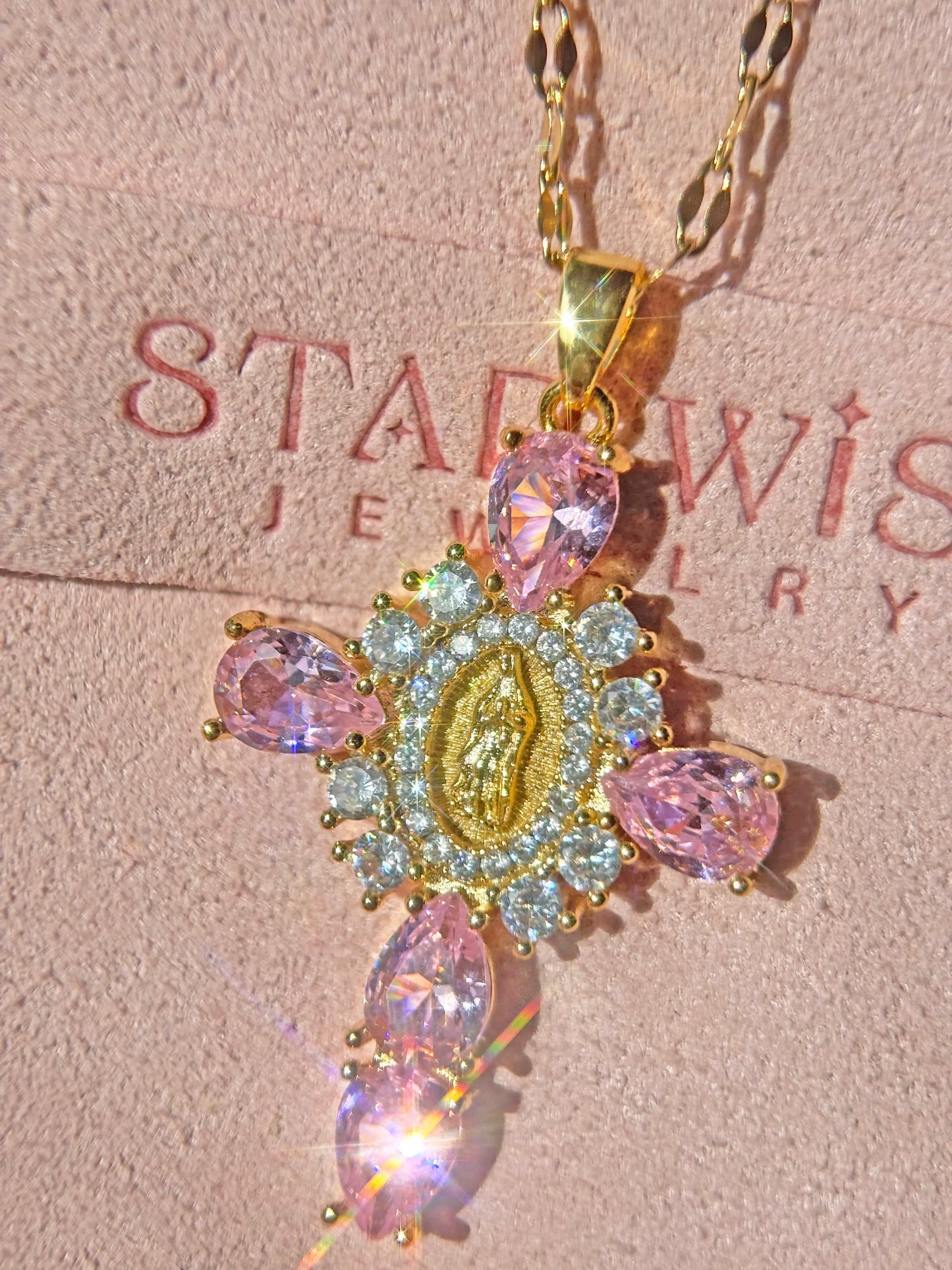 Gold necklace with pink gemstones on a Starwise Jewelry card