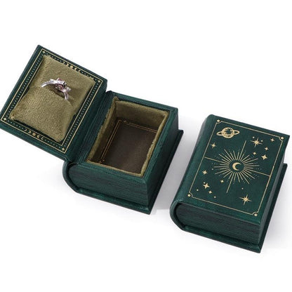 Green book-style jewelry box with moon and stars design 