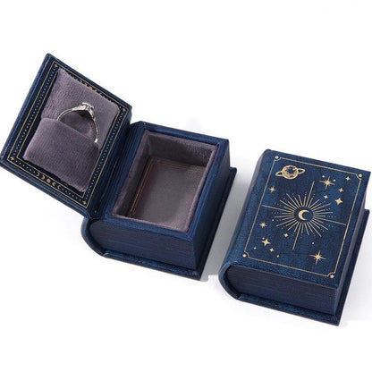 Blue book-style jewelry box with star and moon design 