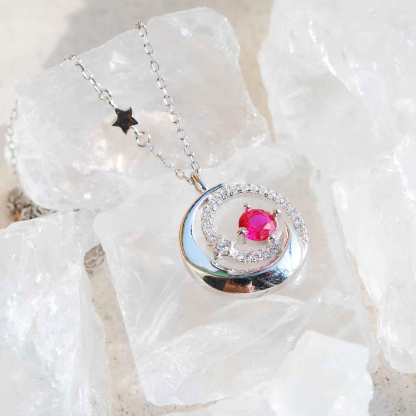 Close up of STAR WISH moon and star necklace with red zircon accents