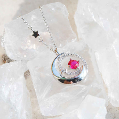Close up of STAR WISH moon and star necklace with red zircon accents