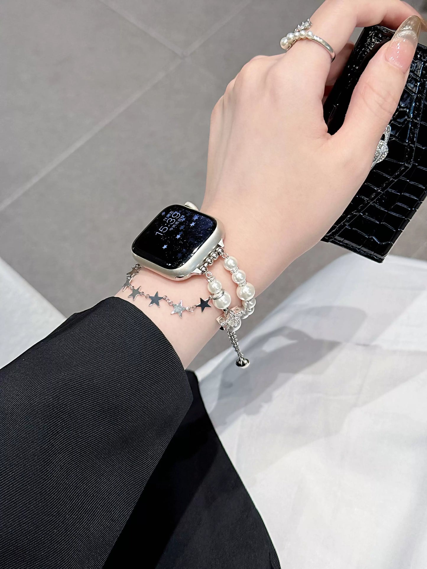 Pearl charm Apple Watch band worn on wrist